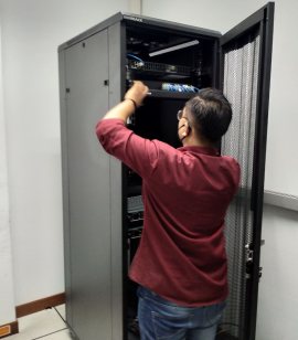 Teknisi memasang perangkat ke dalam kabinet rack.